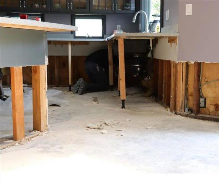 Wood flooring in kitchen is wet and dehumidifier is placed on floor.
