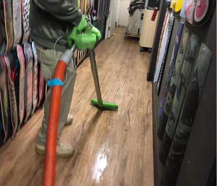 Employee using water extractor on mall flooring
